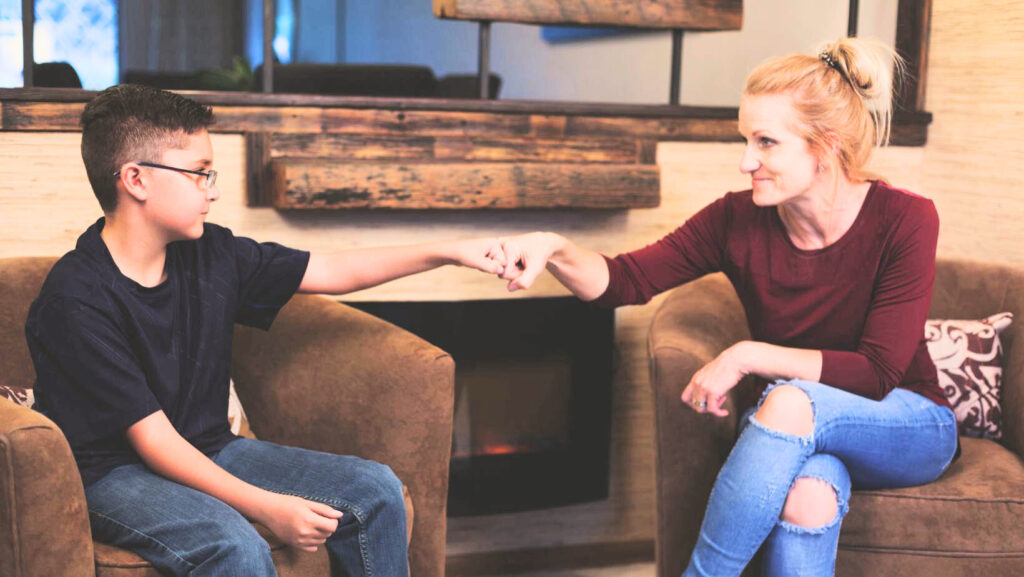 adult and kid fist bumping
