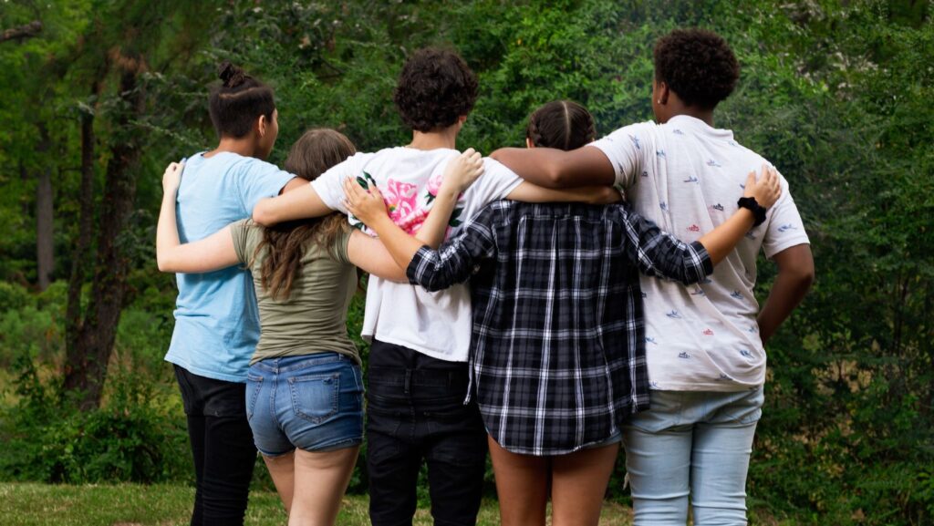 group of teens arms around each other